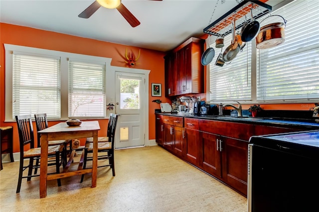 kitchen featuring ceiling fan, stove, and sink