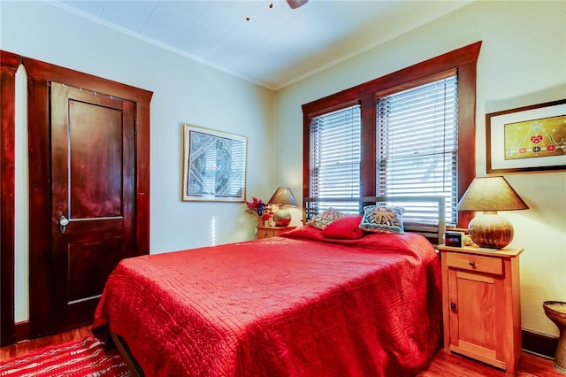 bedroom with ceiling fan, light hardwood / wood-style floors, and ornamental molding