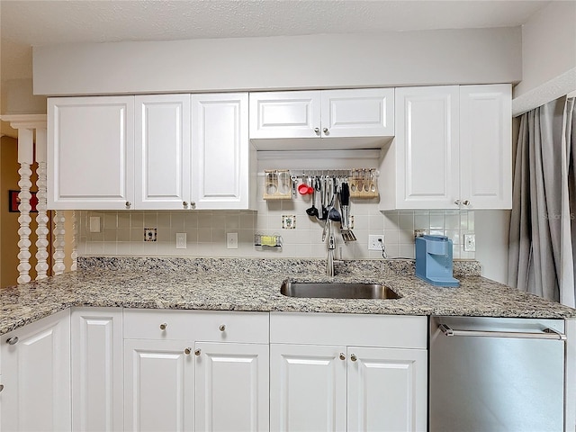 kitchen with decorative backsplash, white cabinetry, and sink