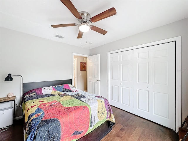 bedroom with dark hardwood / wood-style flooring, ceiling fan, and a closet