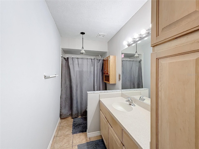 bathroom with tile patterned floors, curtained shower, vanity, and a textured ceiling