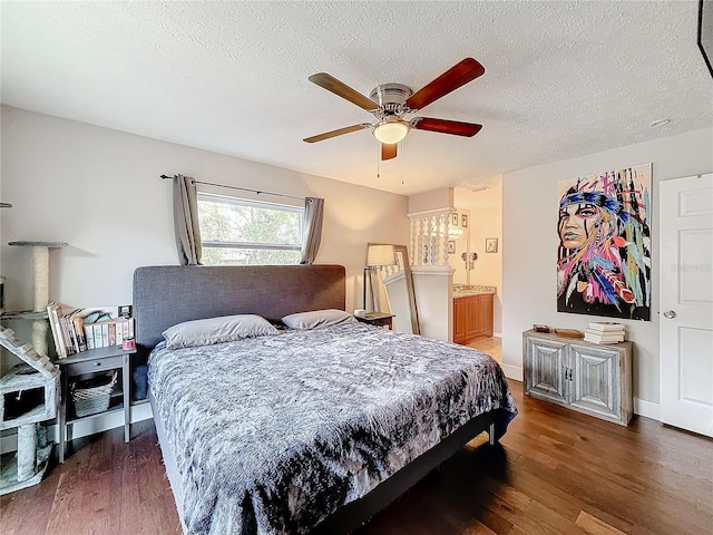 bedroom with a textured ceiling, ensuite bath, ceiling fan, and dark wood-type flooring