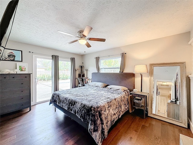 bedroom featuring access to outside, ceiling fan, dark hardwood / wood-style flooring, and a textured ceiling