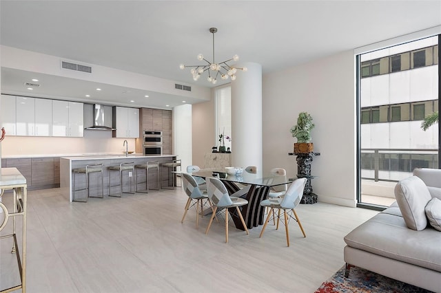 dining area with plenty of natural light, a notable chandelier, and sink