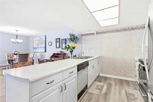 kitchen featuring white cabinets, sink, light wood-type flooring, decorative light fixtures, and stainless steel appliances