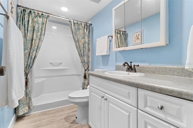 bathroom featuring vanity, toilet, and walk in shower