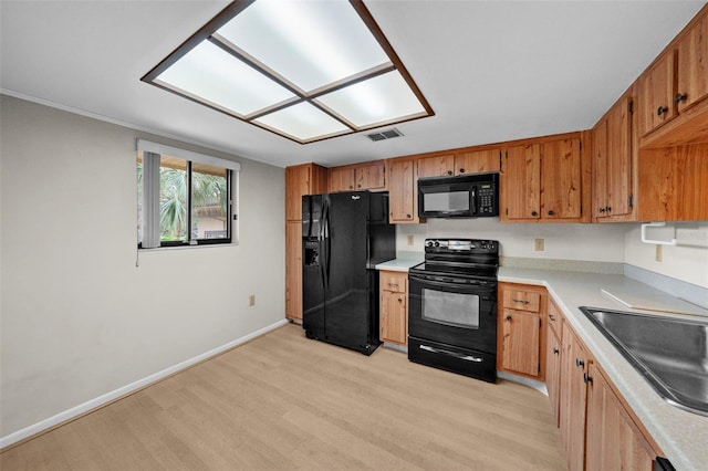 kitchen with sink, light hardwood / wood-style flooring, and black appliances