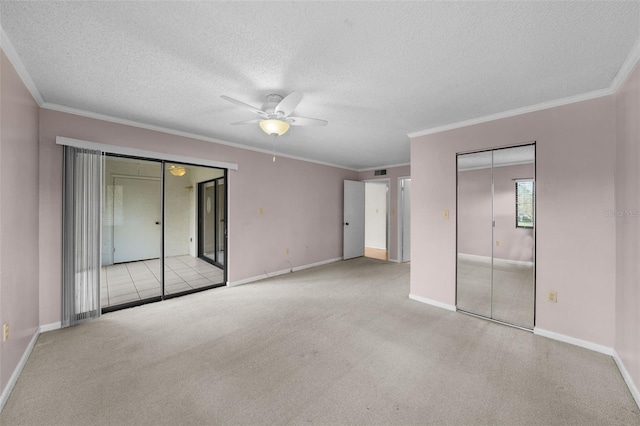 carpeted spare room with ornamental molding, a textured ceiling, and ceiling fan