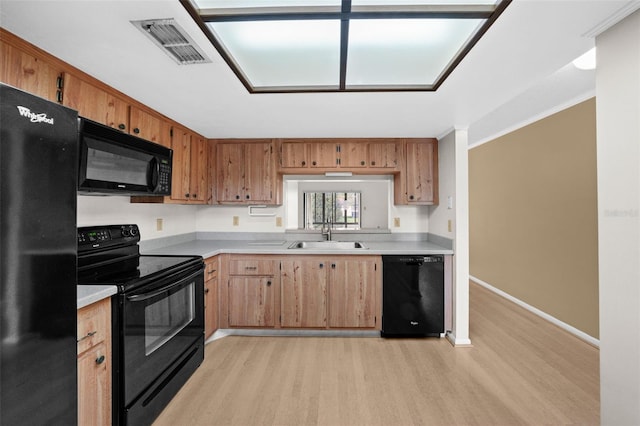 kitchen with light wood-type flooring, sink, and black appliances