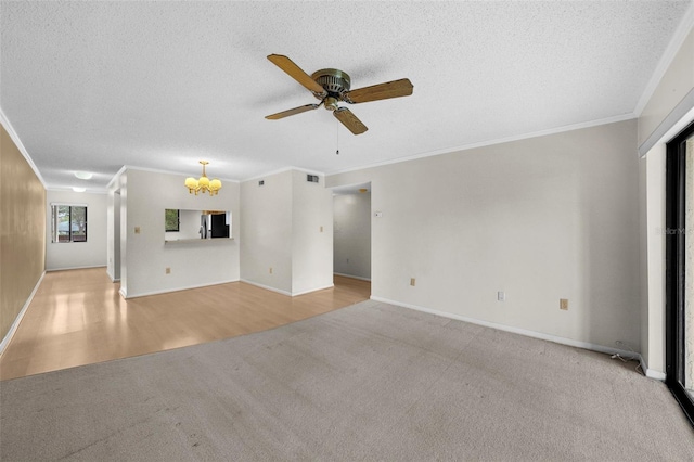 unfurnished living room with light colored carpet, ceiling fan with notable chandelier, ornamental molding, and a textured ceiling