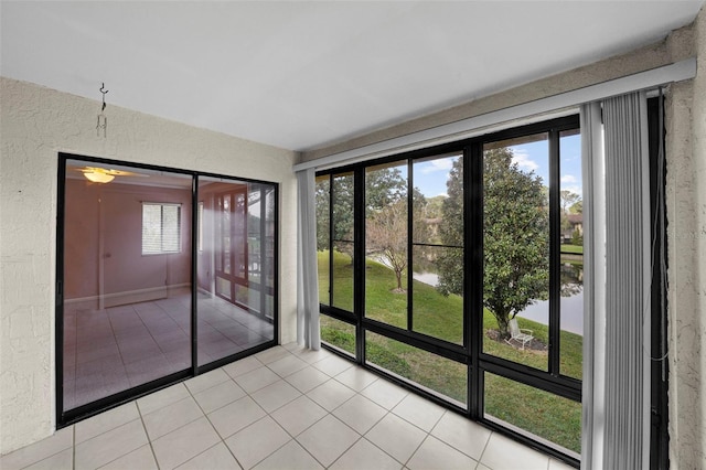 unfurnished sunroom featuring a water view