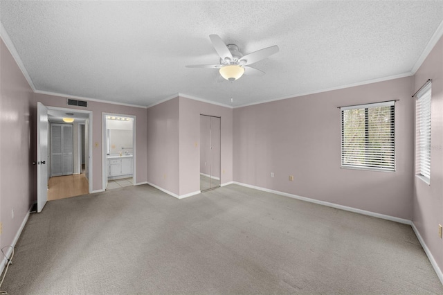 unfurnished bedroom featuring connected bathroom, light carpet, ornamental molding, a closet, and ceiling fan