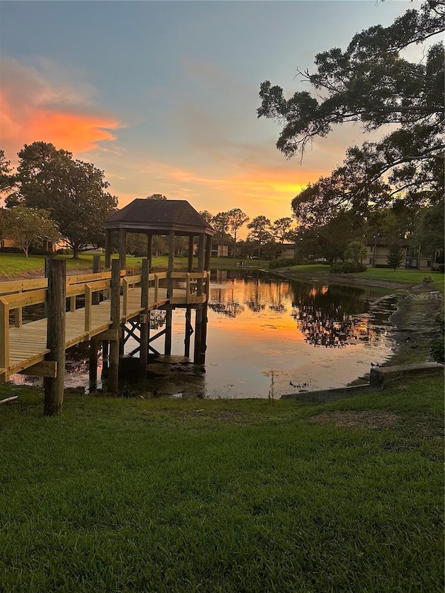 view of dock featuring a yard and a water view