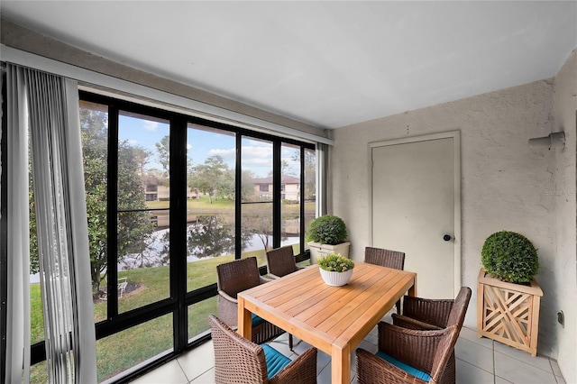 sunroom / solarium featuring a water view