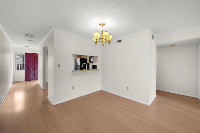 2679 Sabal Springs Cir Unit 203, Clearwater, FL 33761 - unfurnished room featuring hardwood / wood-style floors, a notable chandelier, ornamental molding, and a textured ceiling
