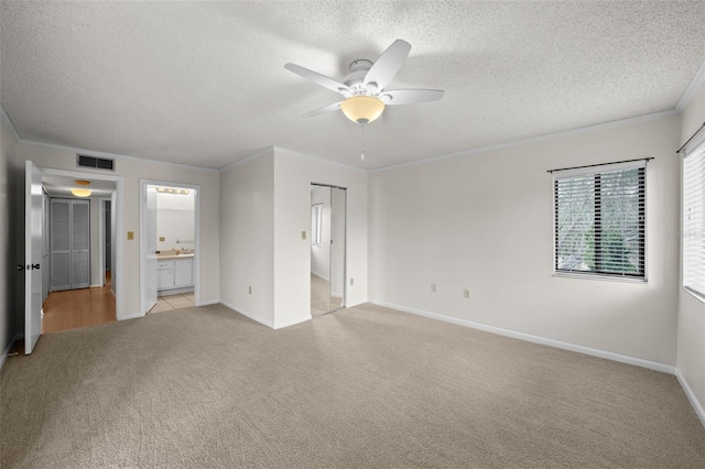 2679 Sabal Springs Cir Unit 203, Clearwater, FL 33761 - unfurnished bedroom with crown molding, light colored carpet, a textured ceiling, and ensuite bathroom