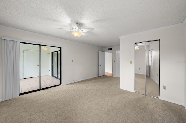 2679 Sabal Springs Cir Unit 203, Clearwater, FL 33761 - unfurnished bedroom featuring multiple closets, crown molding, light colored carpet, and a textured ceiling