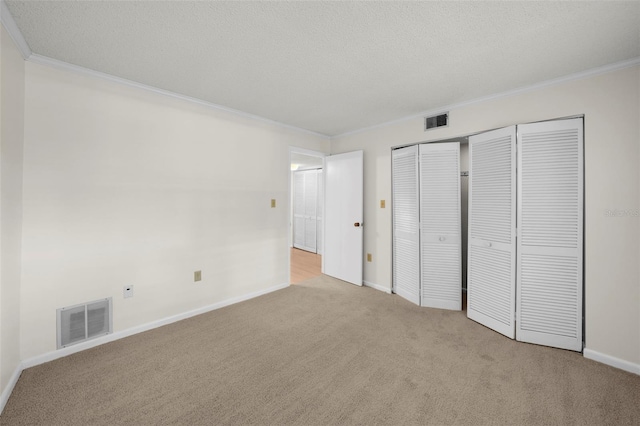 2679 Sabal Springs Cir Unit 203, Clearwater, FL 33761 - unfurnished bedroom with crown molding, light colored carpet, a closet, and a textured ceiling