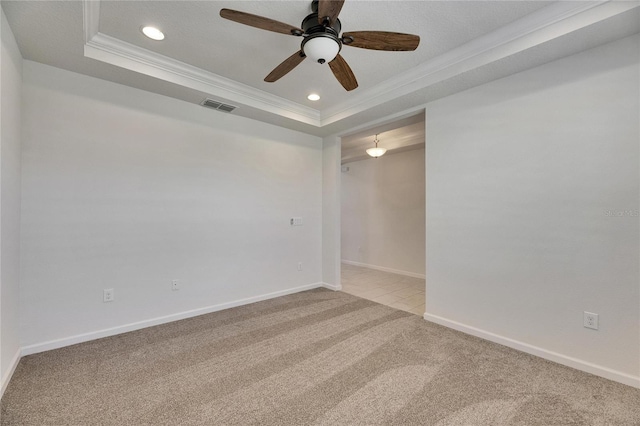 carpeted empty room with a raised ceiling, ceiling fan, and crown molding