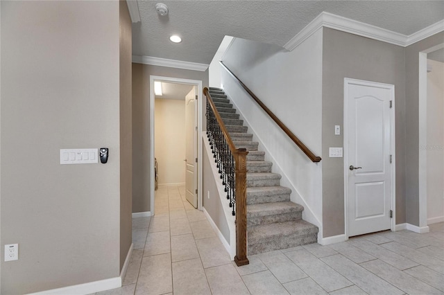 staircase featuring tile patterned flooring, crown molding, and a textured ceiling