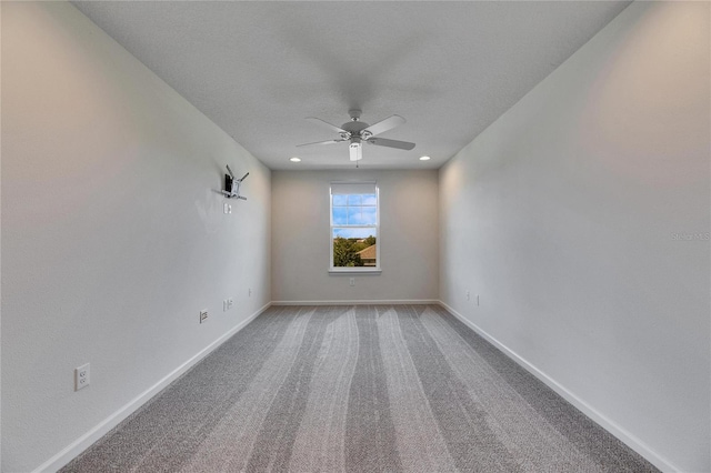 carpeted spare room featuring a textured ceiling and ceiling fan