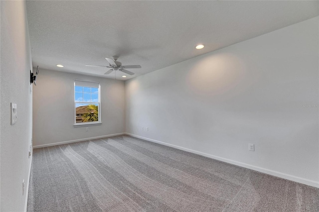 carpeted empty room with a textured ceiling and ceiling fan