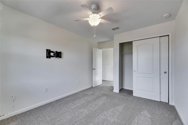 unfurnished bedroom with ceiling fan, a closet, carpet, and a textured ceiling