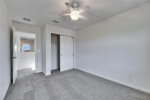 unfurnished bedroom with ceiling fan, a closet, and carpet flooring