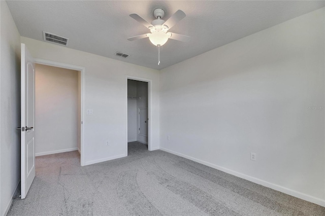 unfurnished bedroom with a closet, ceiling fan, and light colored carpet