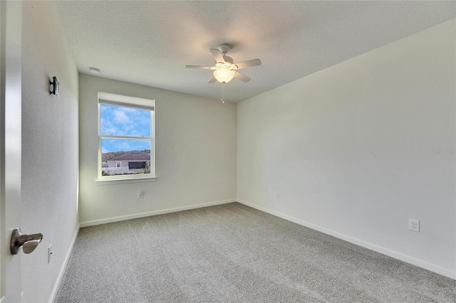 carpeted spare room featuring a textured ceiling and ceiling fan