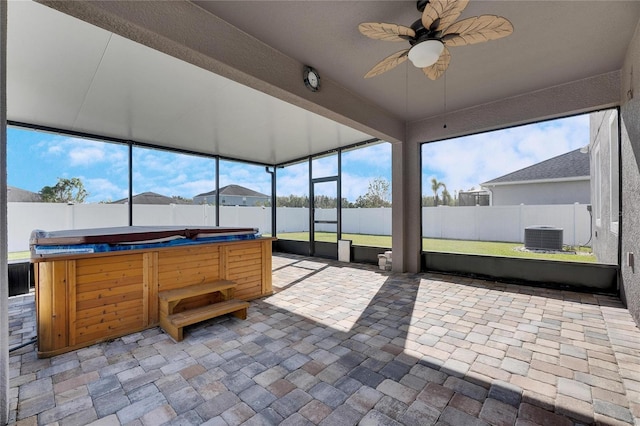 sunroom featuring ceiling fan, a hot tub, and plenty of natural light