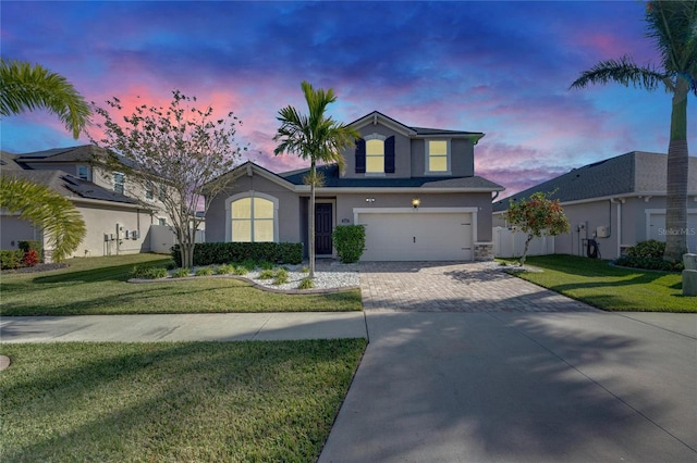 front of property with a garage and a yard