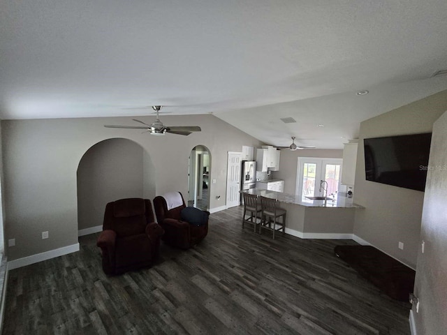 living room featuring lofted ceiling, french doors, sink, dark hardwood / wood-style floors, and ceiling fan