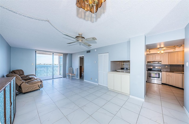 unfurnished living room with floor to ceiling windows, a textured ceiling, and ceiling fan