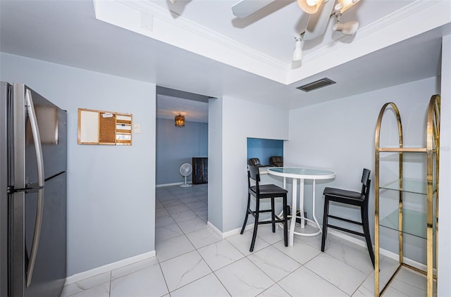 dining space with ceiling fan and ornamental molding