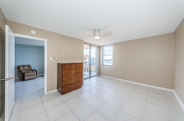 unfurnished bedroom with ceiling fan and a textured ceiling