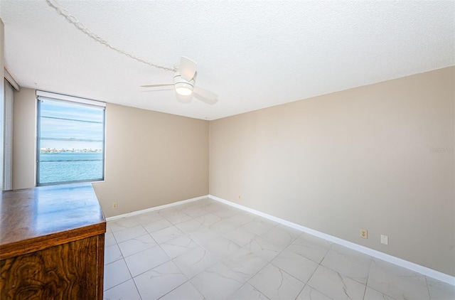 empty room featuring a textured ceiling and ceiling fan