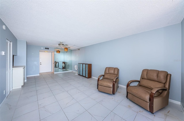 unfurnished room with ceiling fan and a textured ceiling