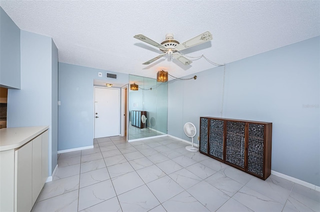 spare room featuring ceiling fan and a textured ceiling