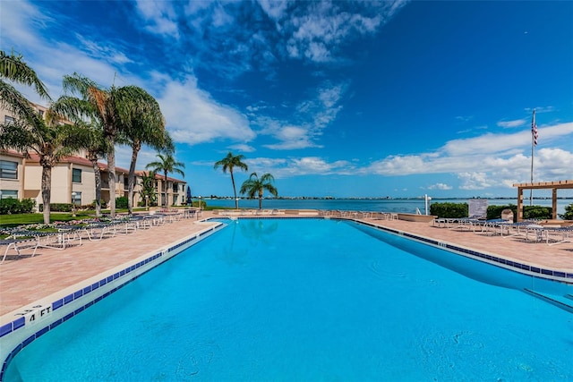 view of pool with a water view and a patio