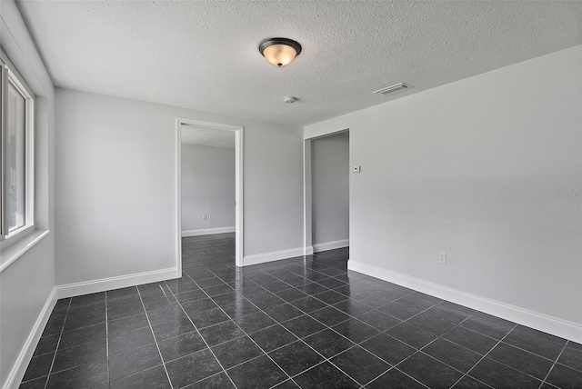 unfurnished room featuring a textured ceiling