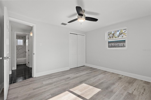 unfurnished bedroom featuring ceiling fan, a closet, and light hardwood / wood-style flooring