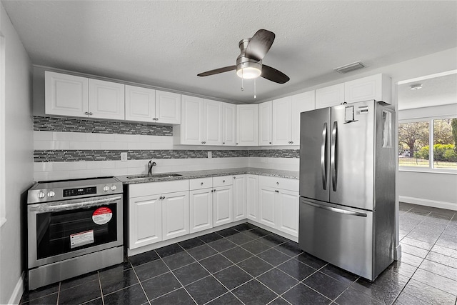 kitchen with white cabinets, stainless steel appliances, ceiling fan, and sink