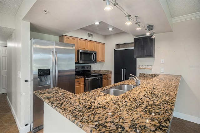 kitchen with kitchen peninsula, sink, stainless steel appliances, and dark tile patterned flooring