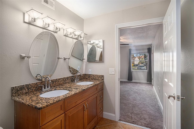 bathroom featuring tile patterned flooring, vanity, and a textured ceiling