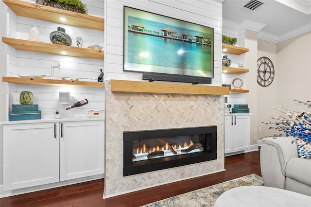 living room with dark hardwood / wood-style flooring, ornamental molding, and a fireplace