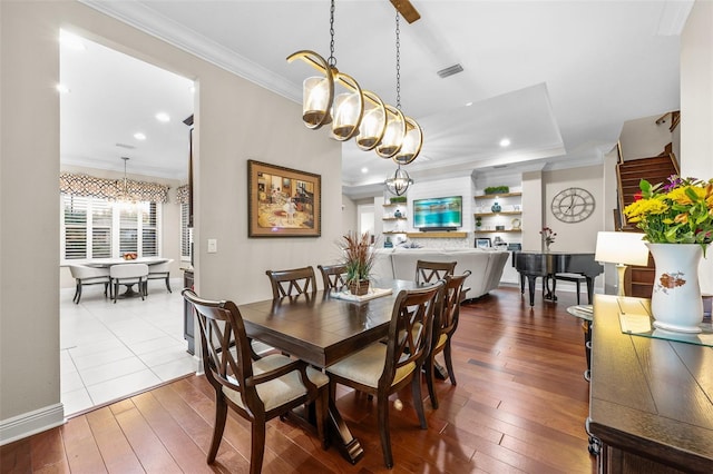 dining area with ornamental molding, a chandelier, and hardwood / wood-style floors