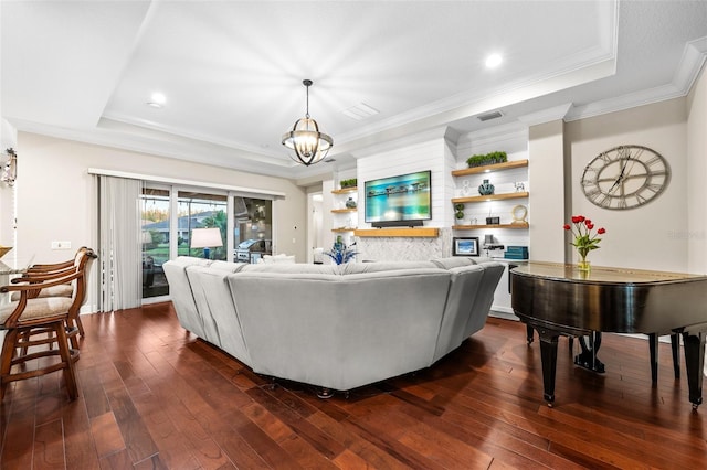 living room featuring a raised ceiling, dark wood-type flooring, and an inviting chandelier