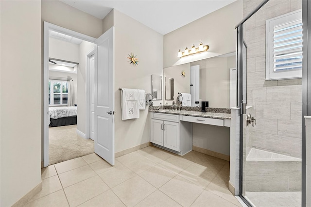 bathroom with an enclosed shower, vanity, a healthy amount of sunlight, and tile patterned flooring