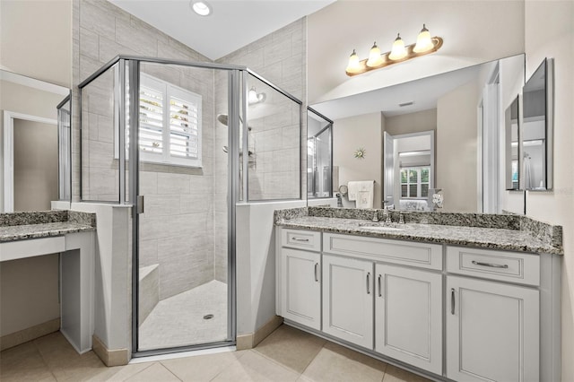 bathroom featuring a shower with shower door, tile patterned floors, and vanity